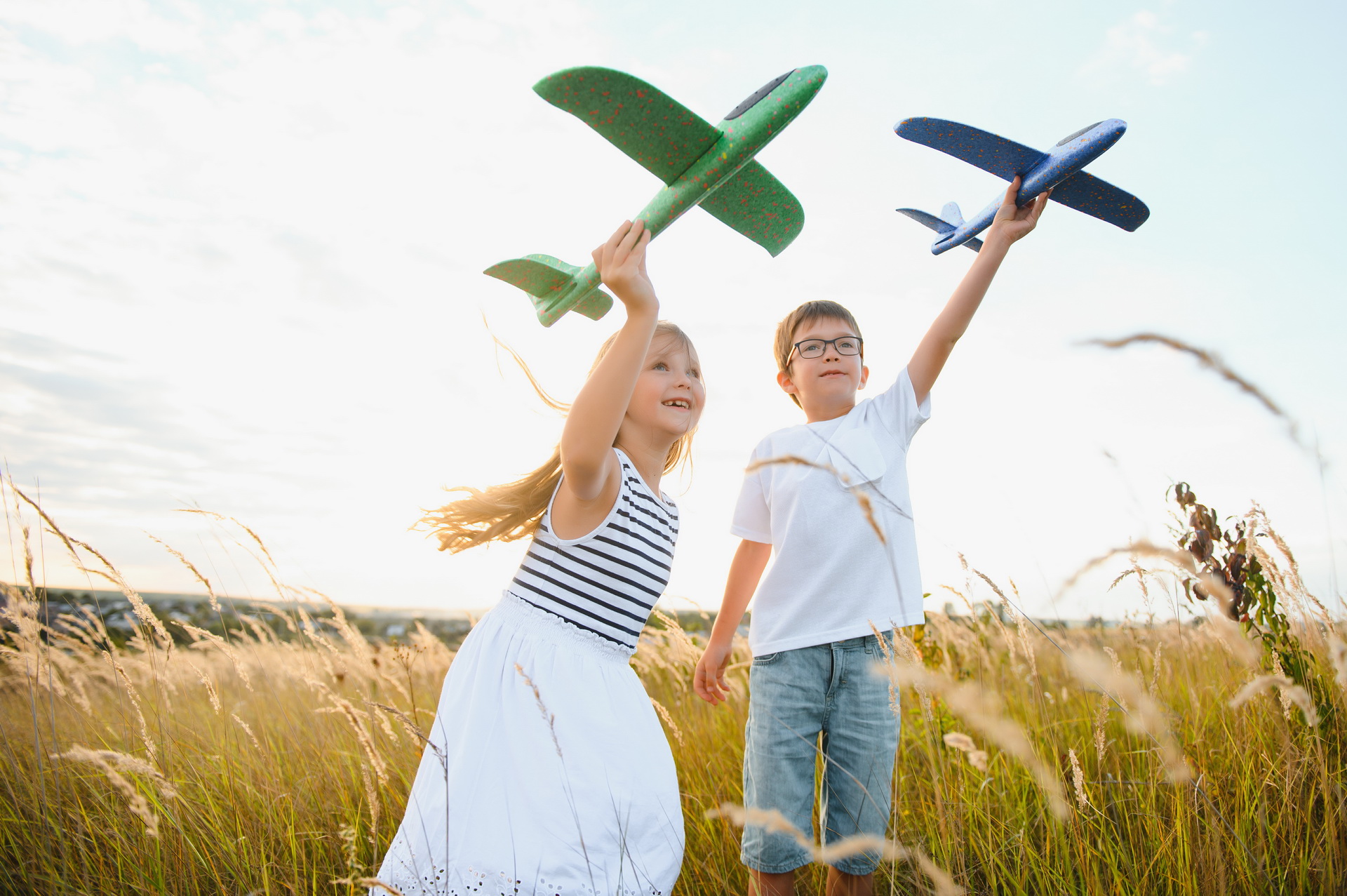 Active running kids with boy holding airplane toy.